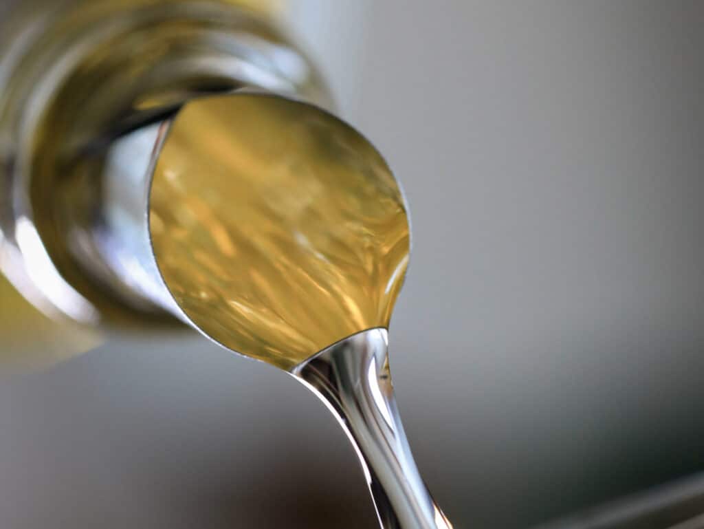 Macro shot of a gold-toned, highly reflective metal object with curved shapes against a gray background.