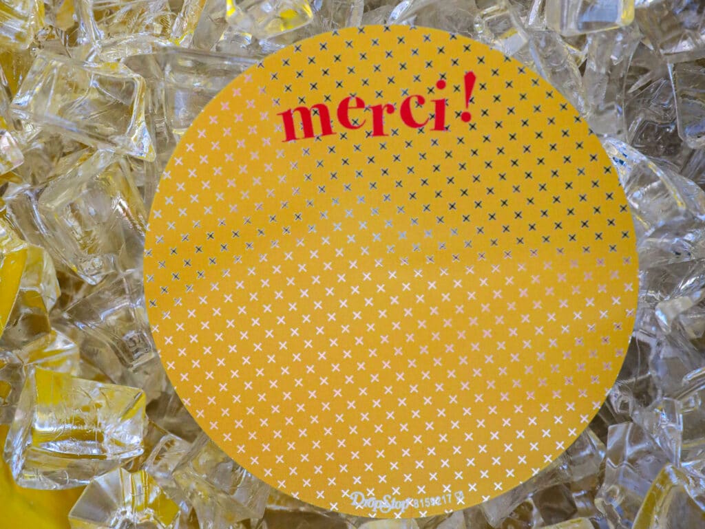 Yellow circle patterned with small white crosses on a bed of crushed ice.