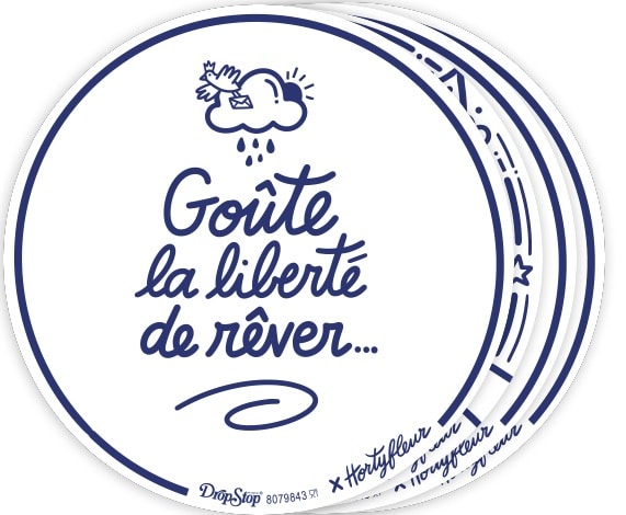 Round blue-edged sticker featuring a handwritten French slogan 'Goûte la liberté de rêver...' with a small cloud illustration above.